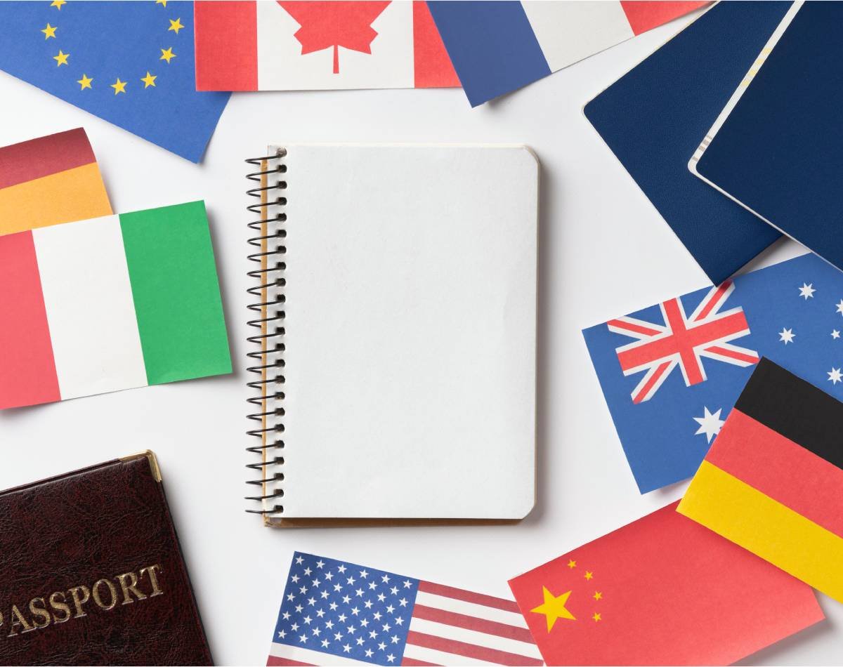 Material de estudio y banderas de varios países representando el proceso de aprender idiomas