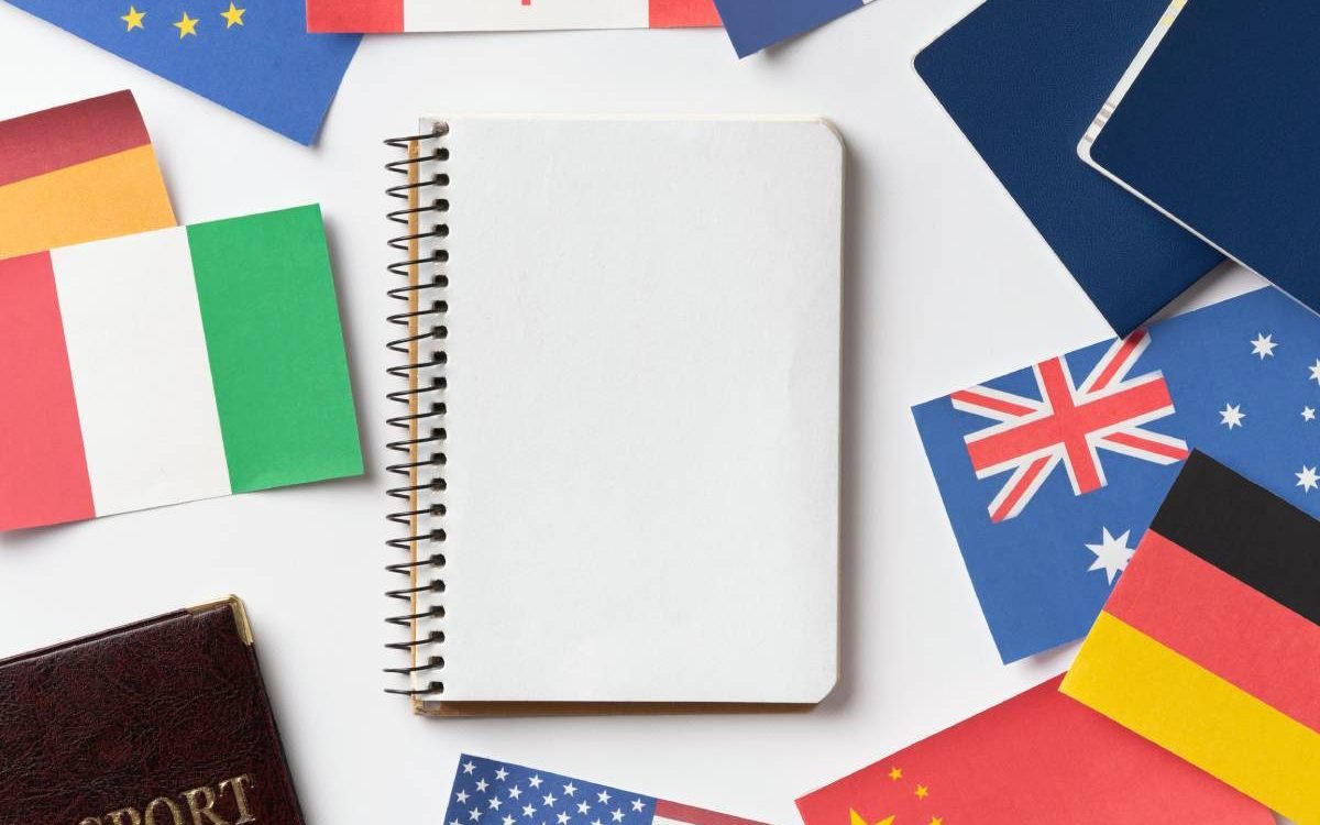Material de estudio y banderas de varios países representando el proceso de aprender idiomas